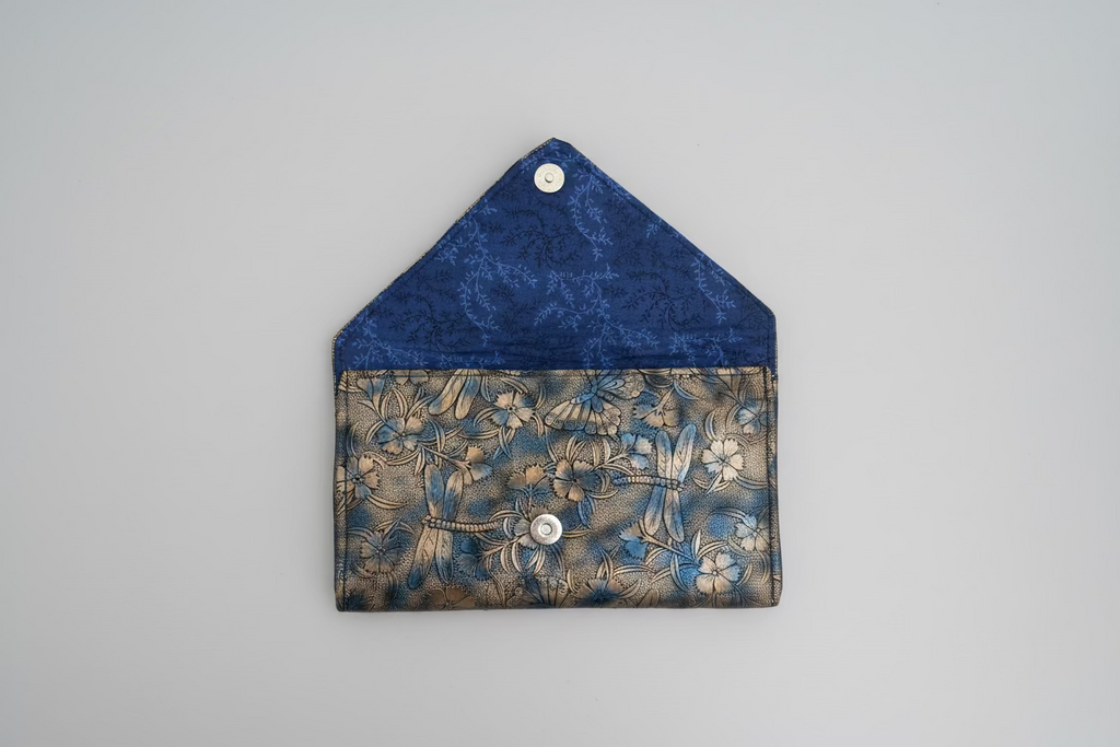Blue and bronze patterned fabric with a button on a beige background