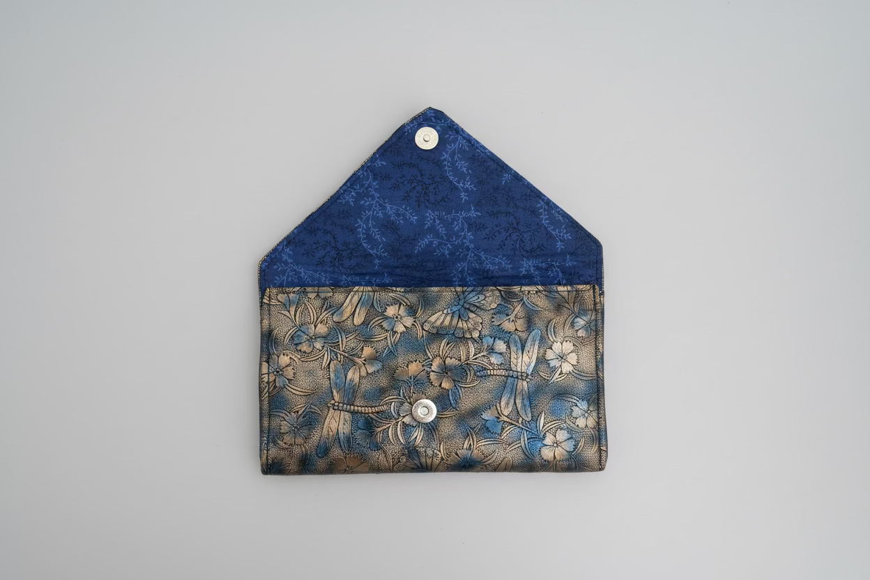 Blue and bronze patterned fabric with a button on a beige background