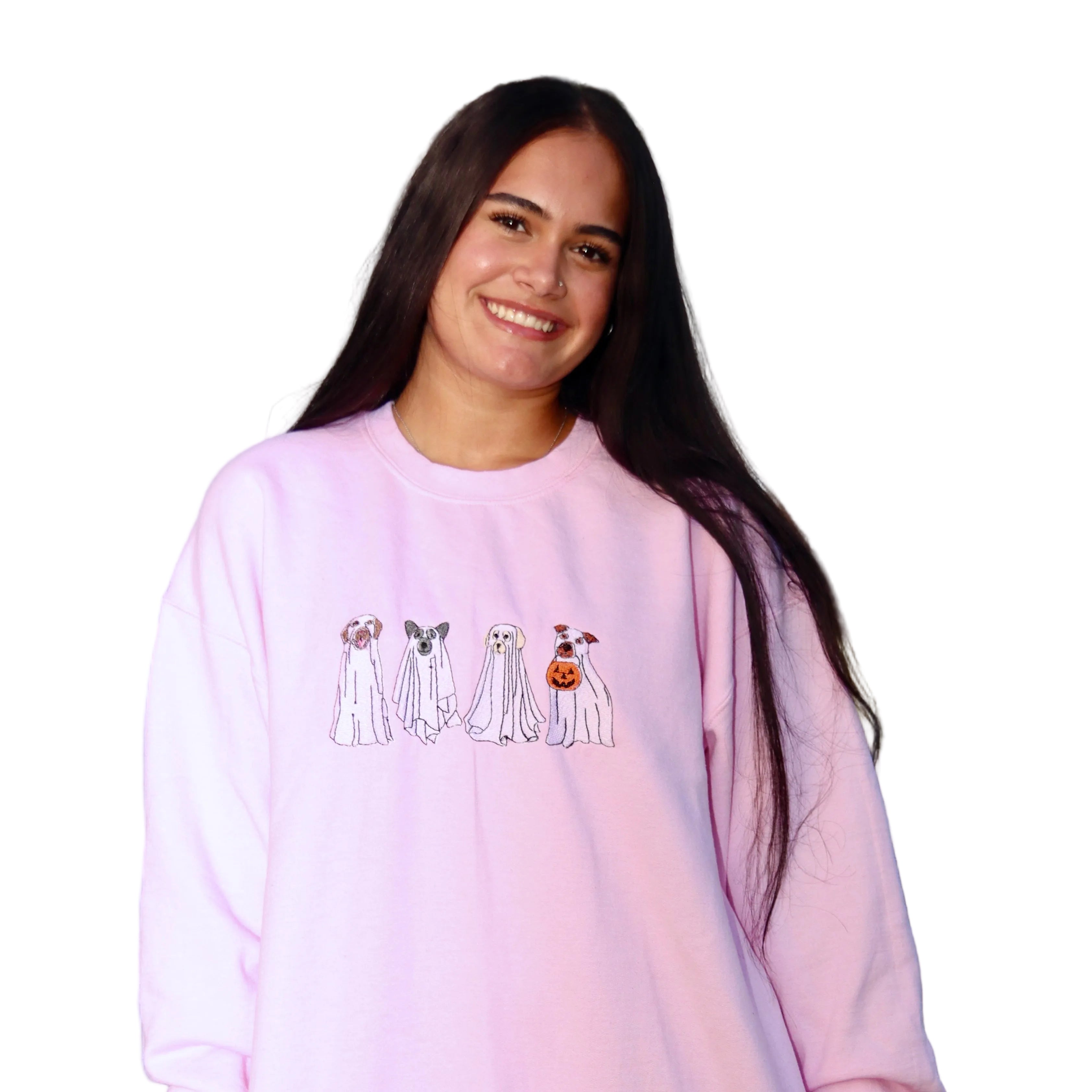 Woman modeling a pink embroidered Ghost Dogs Trick-or-Treat crewneck sweatshirt with four ghost dogs and a pumpkin bucket, perfect for Halloween and fall.