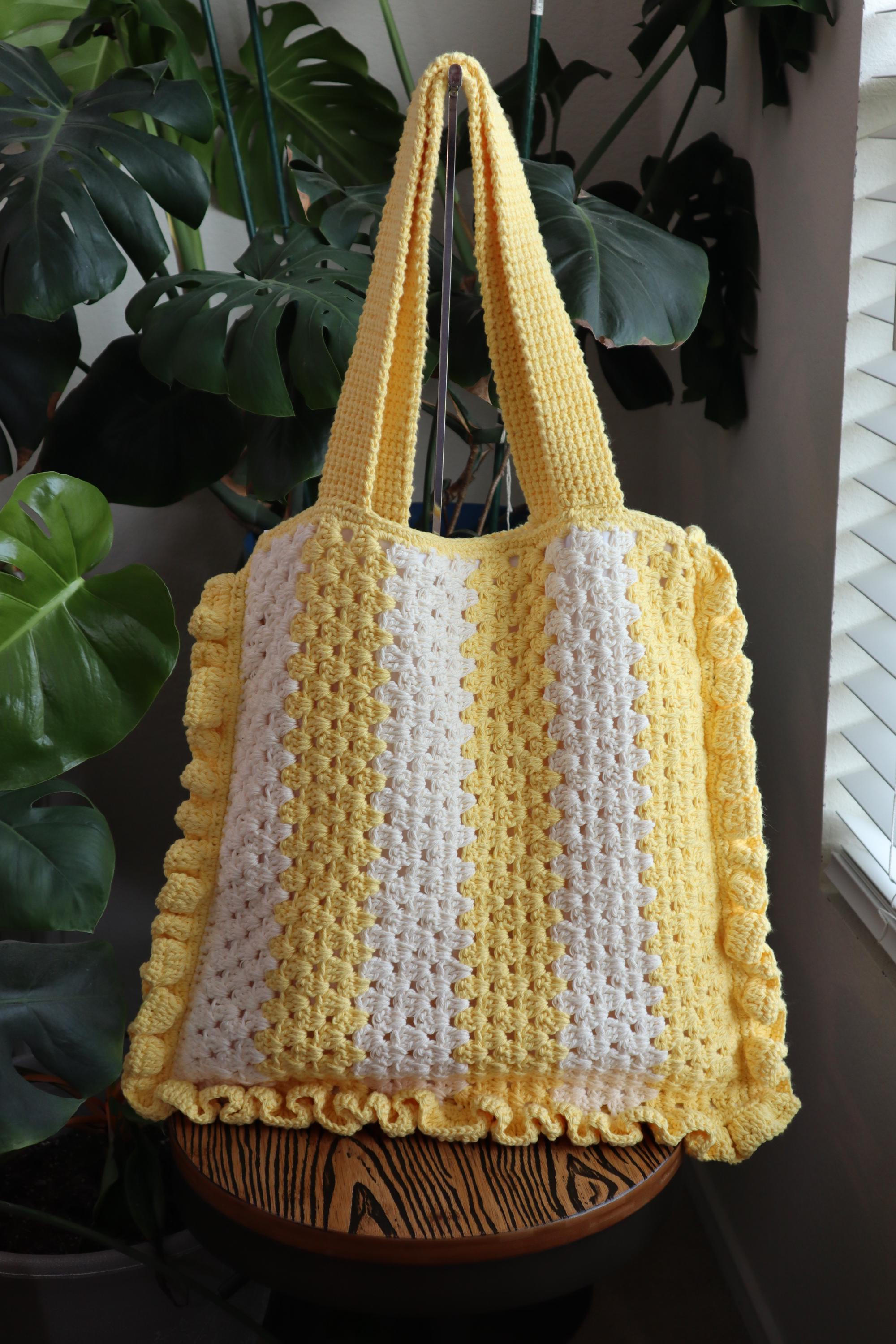 Granny stitch bag with ruffles, fully lined. Behind the bag is a picture of greenery.