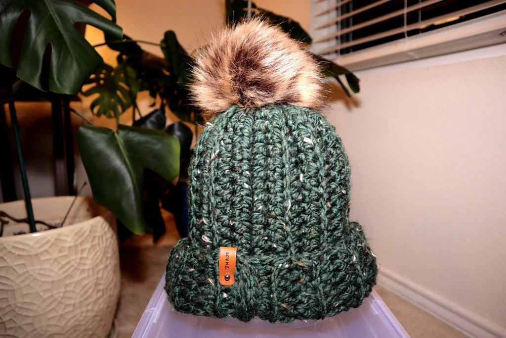 Crocheted green beanie with brown faux fur pom
